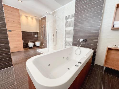 a large white tub in a bathroom with a shower at Hotel Via Vitez in Vitez