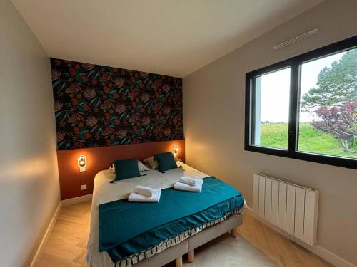 ein Schlafzimmer mit einem Bett und einem großen Fenster in der Unterkunft L'embrun - maison harmonieuse - proche de la mer in Guidel