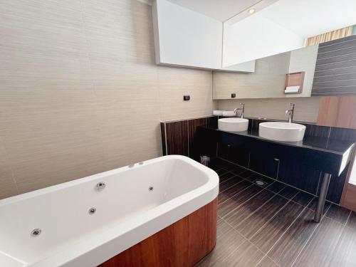 a bathroom with two sinks and a large bath tub at Hotel Via Vitez in Vitez
