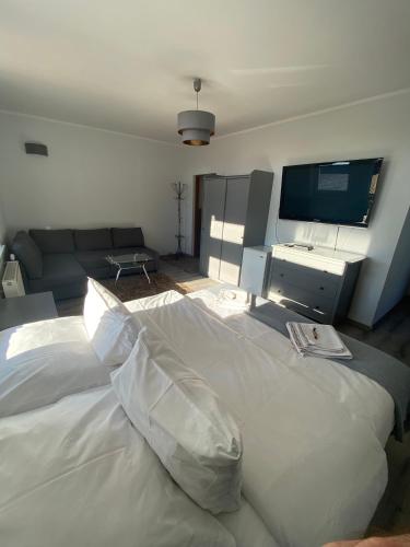 a large white bed in a room with a tv at U Aktorów - Pokoje Gościnne in Elblag