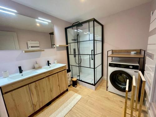 a bathroom with a washing machine and a washer at gite la bergerie in Larressingle