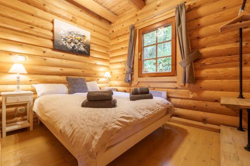 a bedroom with a bed in a log cabin at Chalet des Noisetiers - Magnifique vue montagne in Cornimont
