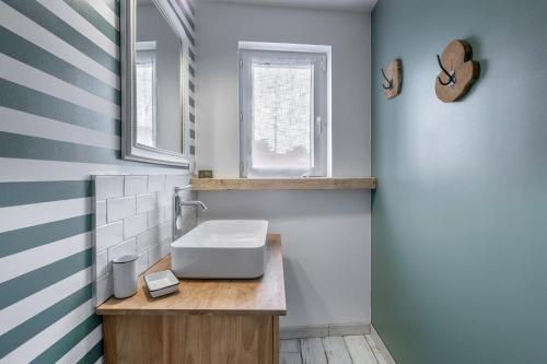 ein Badezimmer mit Waschbecken und Fenster in der Unterkunft À 400m de la plage, maison renovée pour 6 in Préfailles