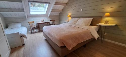 a bedroom with two beds and a table and chairs at Au Bord de l'Eau in Vresse-sur-Semois