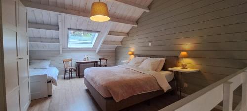 a bedroom with two beds and a table and a window at Au Bord de l'Eau in Vresse-sur-Semois