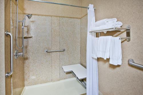 a bathroom with a shower and white towels at Holiday Inn Express Hotel & Suites Bryan-Montpelier by IHG in Holiday City