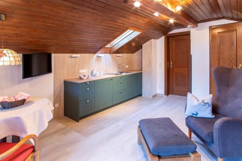 Una sala de estar con un sofá, una silla y una mesa. en Haus St. Korbinian, en Mittenwald
