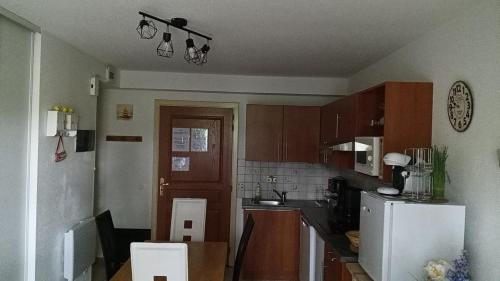 a kitchen with wooden cabinets and a white refrigerator at Le Roi du Sundgau près de la Horse - Mooslargue in Mooslargue