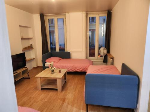 - un salon avec deux lits et un canapé bleu dans l'établissement Logement entier 2-3 p, à Paris