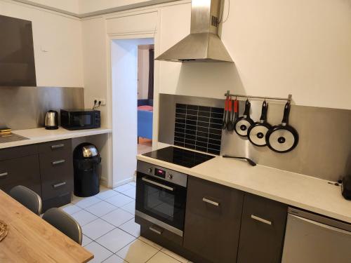 - une cuisine équipée d'une cuisinière et d'un comptoir avec des ustensiles dans l'établissement Logement entier 2-3 p, à Paris