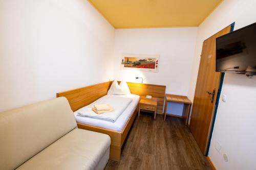 a small room with a bed and a couch at Egidiwirt Murau in Murau