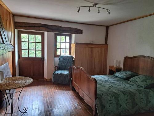 ÉguillyにあるLa Maison des Renouillersのベッドと椅子のある寝室