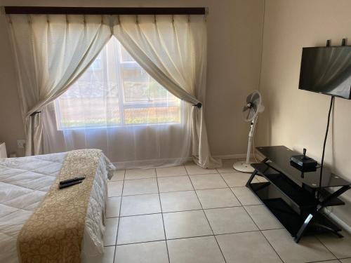 a bedroom with a bed and a window and a television at 16 on Swallow in East London