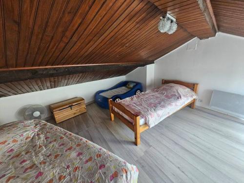 une chambre avec un lit et un plafond en bois dans l'établissement Maison de village dans hameau calme, à Dio-et-Valquières
