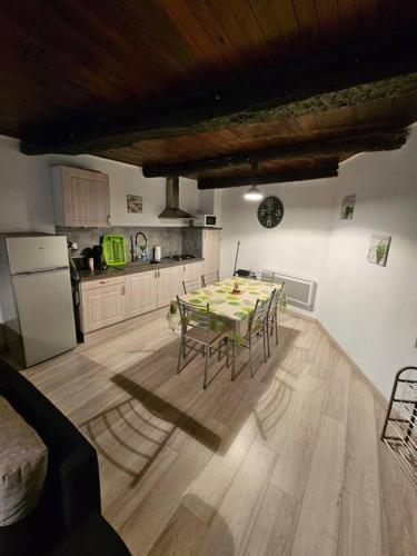 une cuisine avec une table et des chaises dans une pièce dans l'établissement Maison de village dans hameau calme, à Dio-et-Valquières