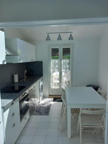 une cuisine blanche avec une table blanche et un comptoir blanc dans l'établissement chez Marie, à Villeneuve-Loubet