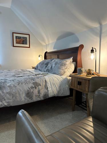 una camera da letto con un letto e un tavolo con una sedia di Peel House Bed and Breakfast a Girvan