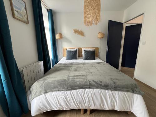 une chambre avec un grand lit avec des rideaux bleus dans l'établissement Oasis Urbaine - 2-4p centre-ville, Place Dalton, à Boulogne-sur-Mer