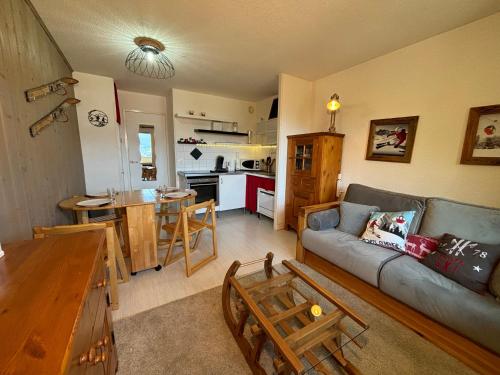 een woonkamer met een bank en een keuken bij Résidence Grand Bois A310 Clés Blanches in La Tania