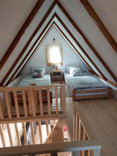 a attic room with two beds and a window at Brvnara Vrganj in Savinac
