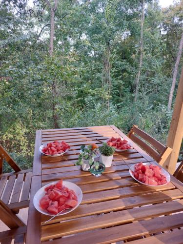 a wooden table with plates of watermelons on it at Brvnara Vrganj in Savinac