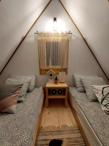 two beds in a pitched room with a table at Brvnara Vrganj in Savinac