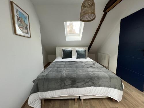 une chambre avec un grand lit dans une pièce dans l'établissement Sous les Toits - Appart Familial 5p, Centre-ville, à Boulogne-sur-Mer