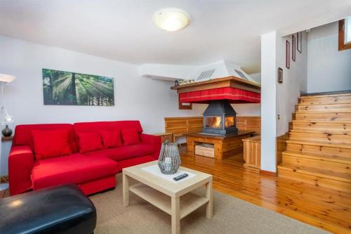 a living room with a red couch and a fireplace at Panoramic House Carnia ,3 badroom chalet Ligosullo - Treppo Carnico - Paluzza - Zoncolan in Ligosullo