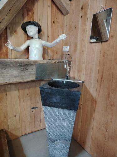 une salle de bain avec un lavabo et une statue d'homme dans l'établissement La Belle Étoile, à La Chartre-sur-le-Loir