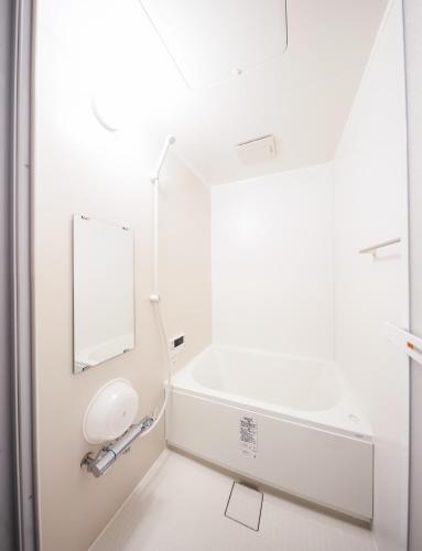 a white bathroom with a mirror and a sink at つなぐ古民家 in Kaizuka