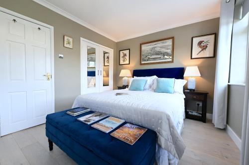 a bedroom with a large bed and a blue ottoman at En-suite luxury large bedroom with parking and two tickets to Kew Gardens in Kew Gardens