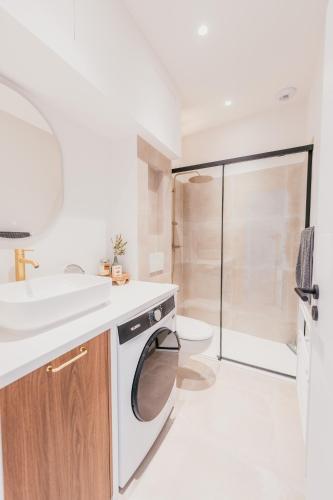 une salle de bain avec un lavabo et une machine à laver dans l'établissement Chic T2 climatisé proche plages, à Châteauneuf-les-Martigues
