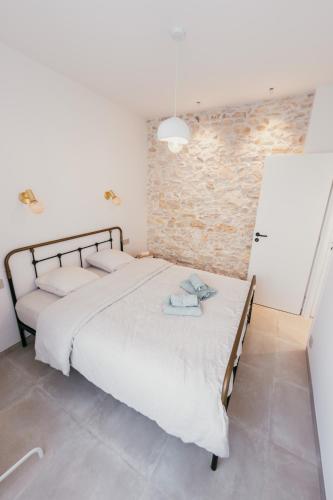 une chambre avec deux lits et un mur de briques dans l'établissement Chic T2 climatisé proche plages, à Châteauneuf-les-Martigues