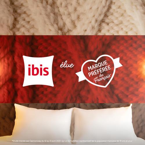 a bed with two pillows with the words ibs and a pillow with at ibis Lyon Centre in Lyon