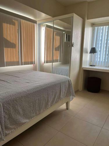 a bedroom with a bed and a mirror at Belle's Staycation in Cebu City