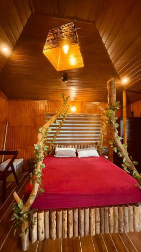 a bedroom with a large bed with a red blanket at Ela Forest Stay in Kannādi