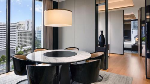 a dining room with a table and chairs and a large window at InterContinental Singapore Robertson Quay by IHG in Singapore