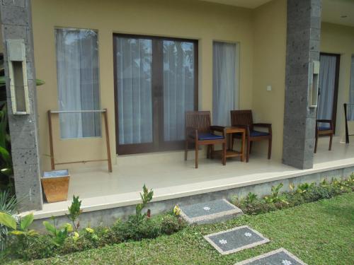 a patio with chairs and a table on a house at Biyukukung Suite & Spa in Ubud