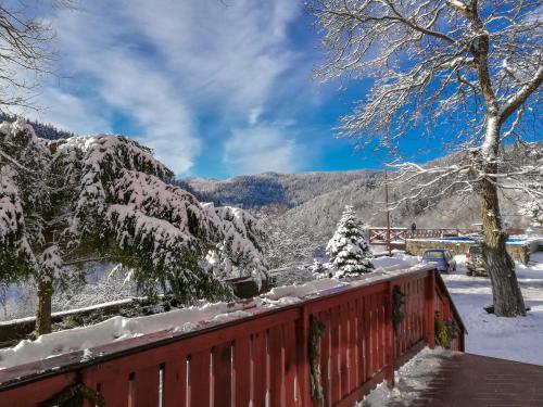 a red fence covered in snow with mountains in the background at Ośrodek Wypoczynkowy Pod Dębem in Wójtowice