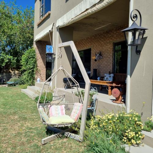 a swinging chair in the yard of a house at The Fat Mulberry Guest Farm in Fouriesburg