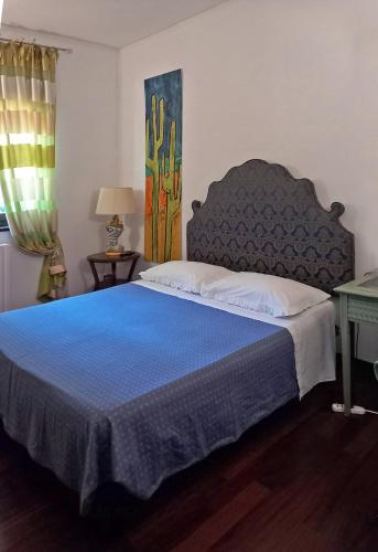 a bedroom with a large bed with a blue blanket at Labella Villa in Viterbo