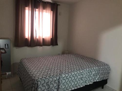 a bedroom with a bed and a window with a bedspread at CONDOMÍNIO BOSQUE IMPERIAL ll in João Pessoa
