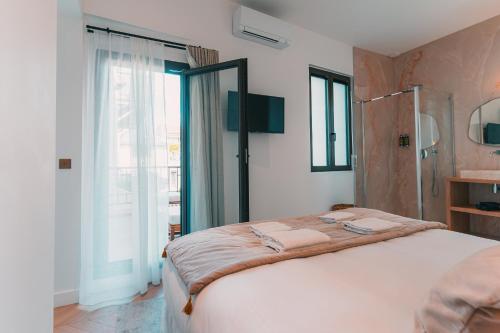 une chambre avec un grand lit et une grande fenêtre dans l'établissement Prestigieux T6 au Vieux Port by Maison Galante, à Marseille