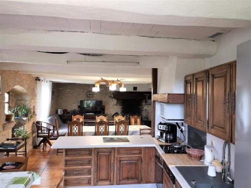 une cuisine avec des placards en bois et une salle à manger dans l'établissement GITE Piscine CAHORS, à Aujols