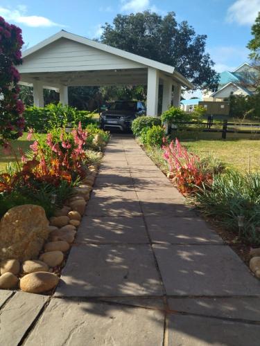a sidewalk in front of a house with flowers at Villa Caylee Caribbean Estates - Ultra-Luxurious - Rimas Interiors Designs - Private Beachfront Escape - Premium serviced for 8 Guests in Port Edward
