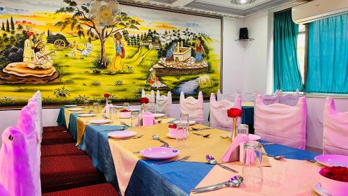 a dining room with tables with pink and blue table cloth at Hotel Master Paradise, Pushkar, Rajasthan , INDIA in Pushkar