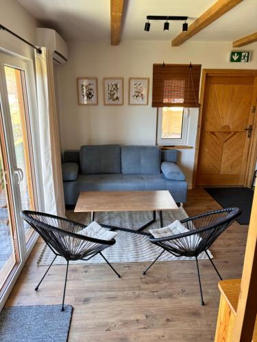 a living room with a couch and a table at Kokuszka Village - domki drewniane in Piwniczna-Zdroj