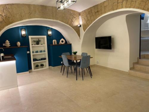 una sala da pranzo con pareti blu, tavolo e sedie di Domus Parthenope Deluxe a Napoli