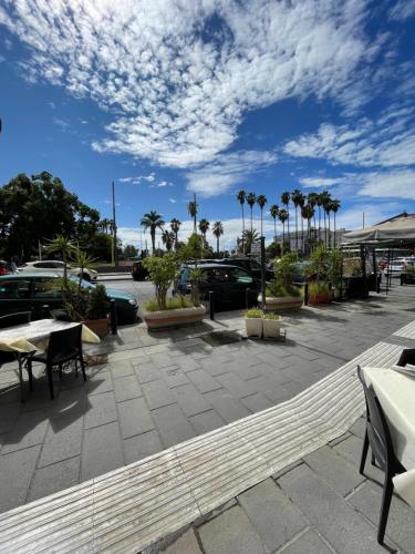 un parcheggio con tavoli, sedie e palme di Domus Parthenope Deluxe a Napoli