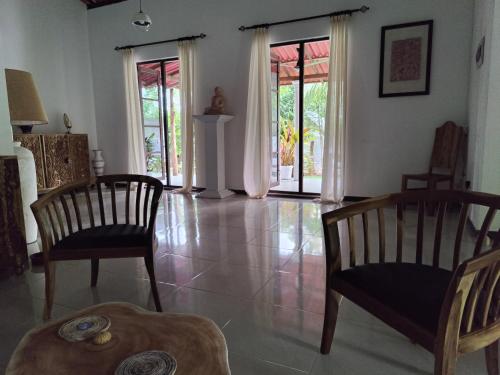 a living room with two chairs and a table at Villa Lyvie ayurvedic hotel in Tangalle